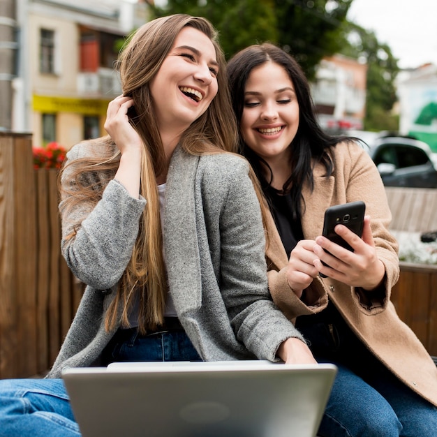 Vrienden die buiten op een smartphone kijken