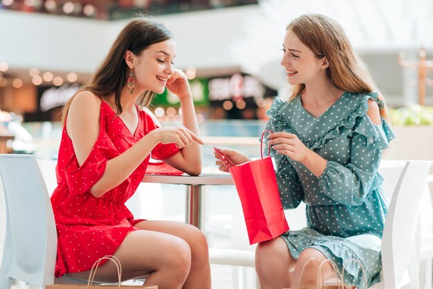 Vrienden die en bij winkelcentrum zitten spreken