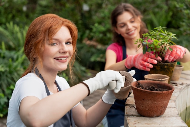 Vrienden die in een kas voor hun planten zorgen