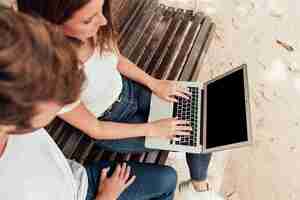 Gratis foto vrienden die laptop controleren op een bank