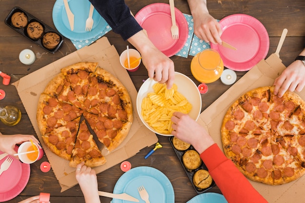 Vrienden die pizza eten op een feestje