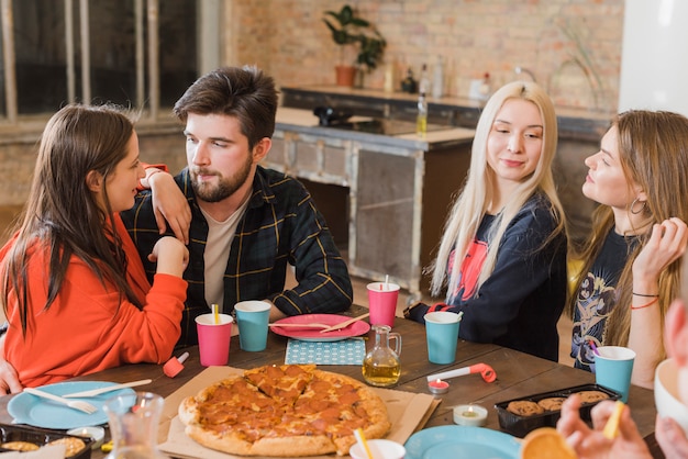 Vrienden die pizza eten op een feestje