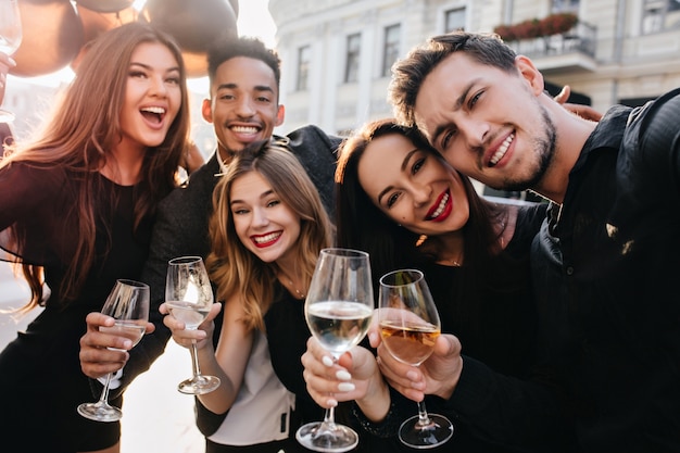 Vrienden die plezier hebben en buiten champagne drinken