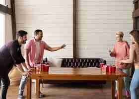 Gratis foto vrienden die samen bierpong spelen op een feestje