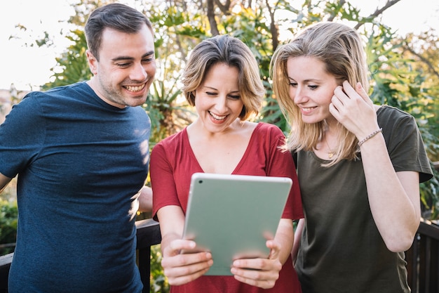 Vrienden die tablet gebruiken dichtbij omheining