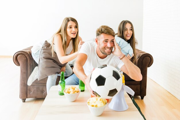 Vrienden die voor voetbalteam thuis toejuichen