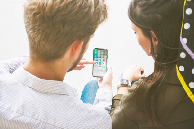 Gratis foto vrienden gebruiken applicatie op mobiele telefoon door verbinding te maken met smartwatch