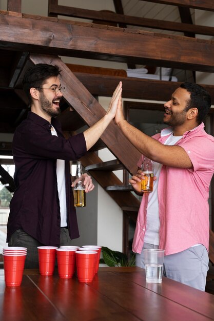 Vrienden geven elkaar een high-five tijdens een bierpongspel