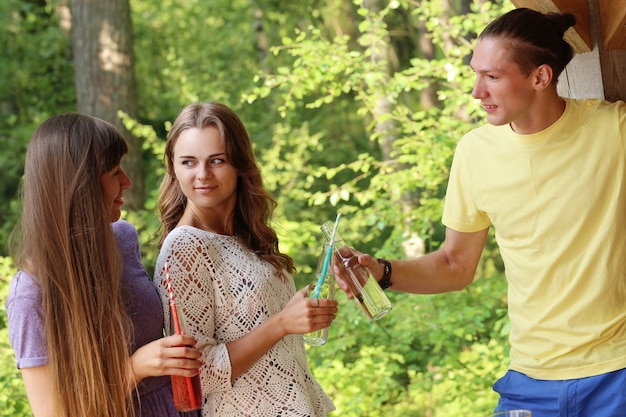 Vrienden hebben plezier en drinken in het kamp