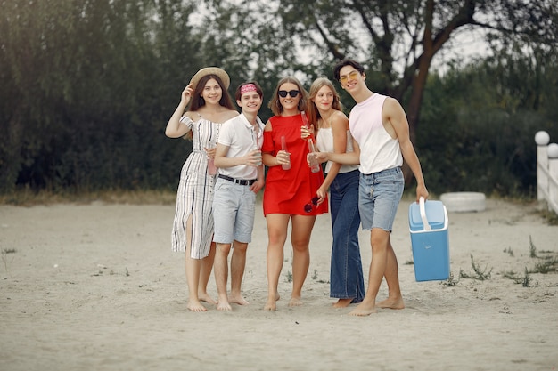 Vrienden hebben plezier op een strand met drankjes