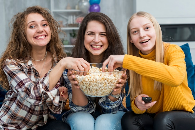 Vrienden kijken naar een film terwijl ze popcorn eten