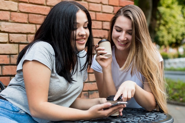 Gratis foto vrienden kijken naar iets leuks op een slimme telefoon