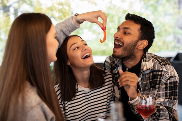 Vrienden lachen en eten tijdens een borrel en eten