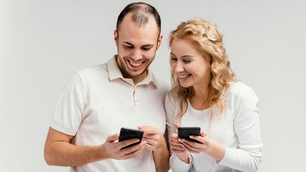 Vrienden lachen en gebruiken mobiele telefoons