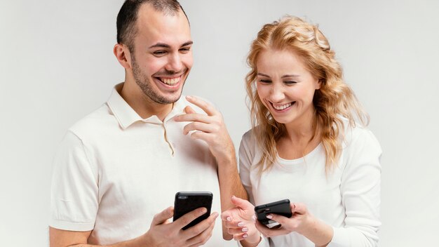 Vrienden lachen en gebruiken mobiele telefoons