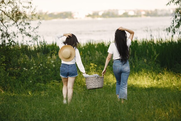 Vrienden lopen. Meisjes met een mand. Vrouw in een wit overhemd.