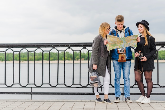 Gratis foto vrienden met kaart aan de waterkant