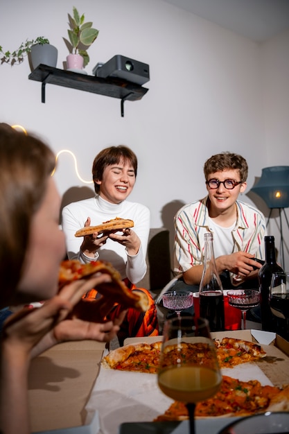 Gratis foto vrienden op een feestje met heerlijke pizza.