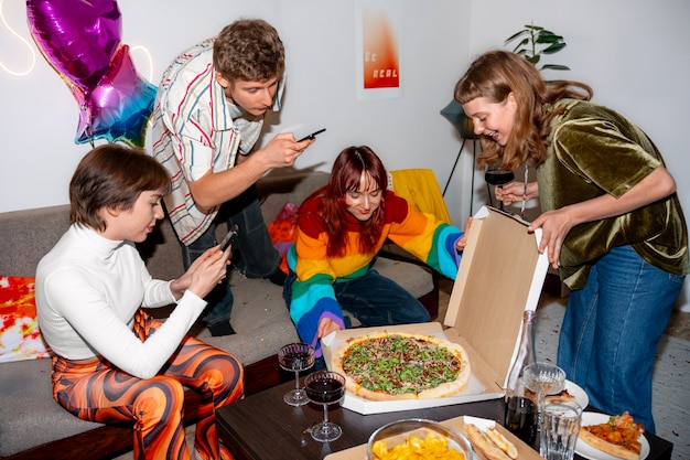 Gratis foto vrienden op een feestje met heerlijke pizza.