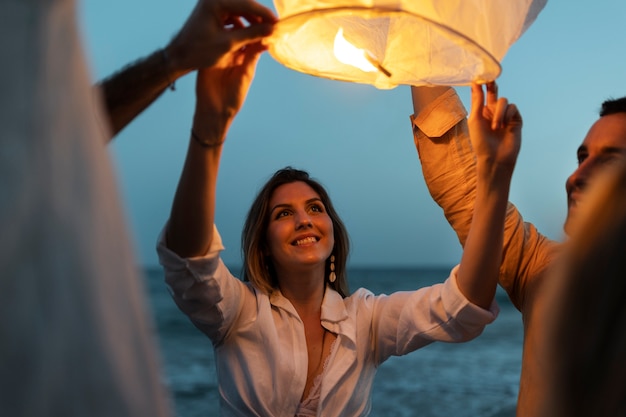 Vrienden op het strand die 's nachts de lantaarn lanceren