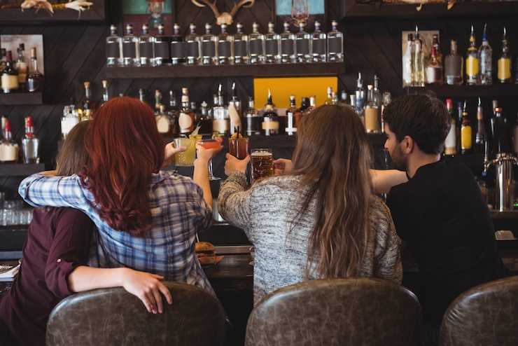 Gratis Foto vrienden roosteren met bier en cocktailglazen in staaf