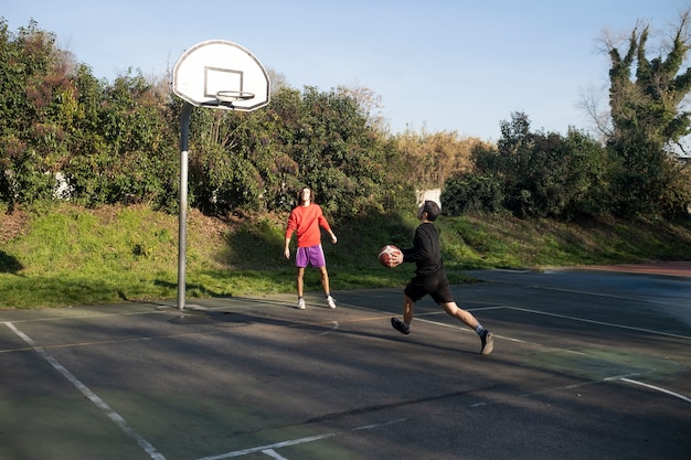 Gratis foto vrienden van middelbare leeftijd die samen plezier hebben met basketballen