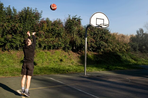 Vrienden van middelbare leeftijd die samen plezier hebben met basketballen