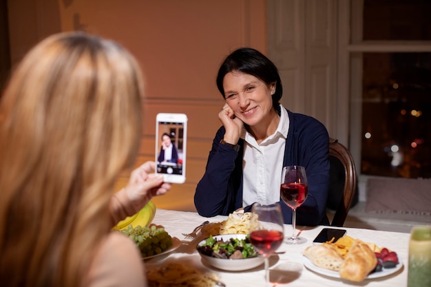 Vrienden van middelbare leeftijd 's avonds aan het eten