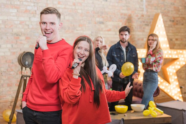 Vrienden zingen karaoke op een feestje