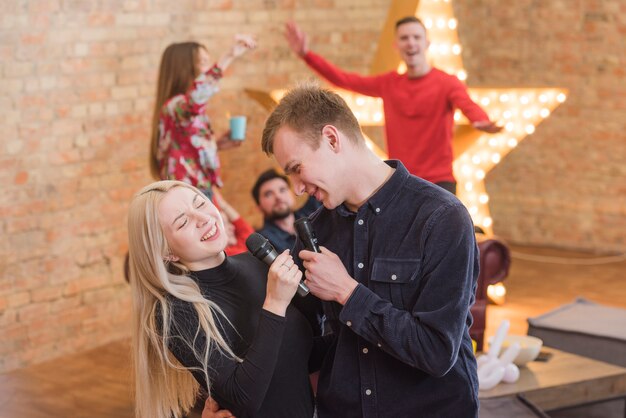 Vrienden zingen karaoke op een feestje