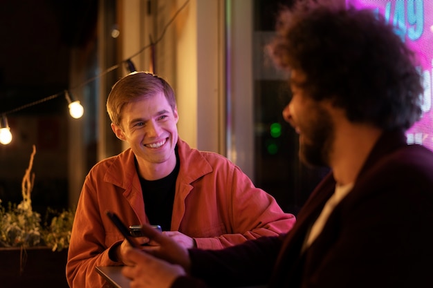 Vrienden zitten aan een tafel en praten tijdens een avondje uit