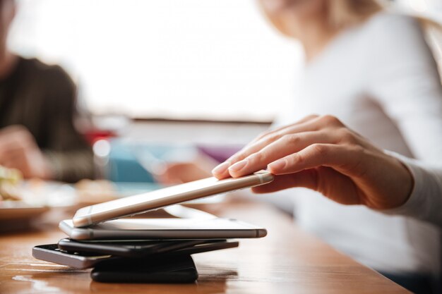 Vrienden zitten in café. Vrouw wat betreft telefoon.