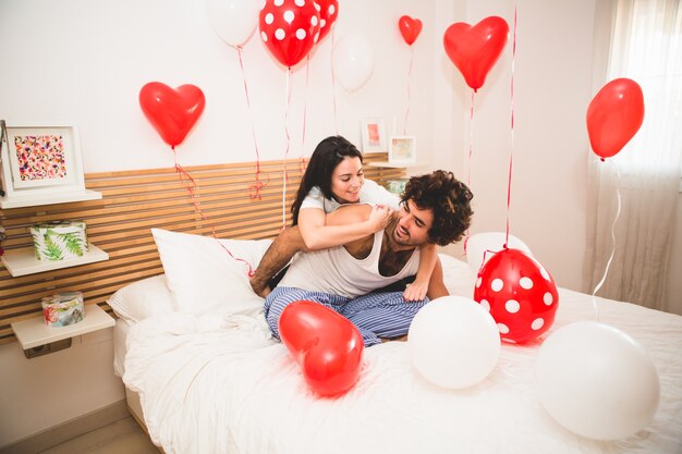 Vriendin klimmen rug van haar vriendje op het bed