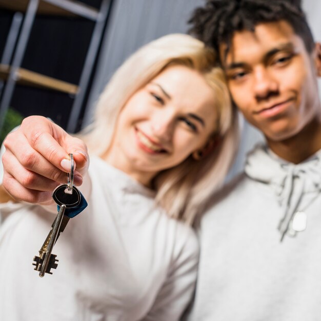 Vriendin met haar vriend die huissleutel naar camera toont