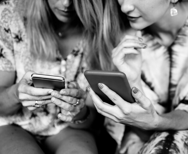 Vriendinnen communiceren en verbonden via de mobiele telefoon