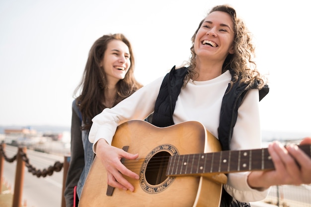 Gratis foto vriendinnen gitaar spelen