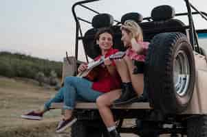 Gratis foto vriendinnen gitaarspelen tijdens het reizen met de auto