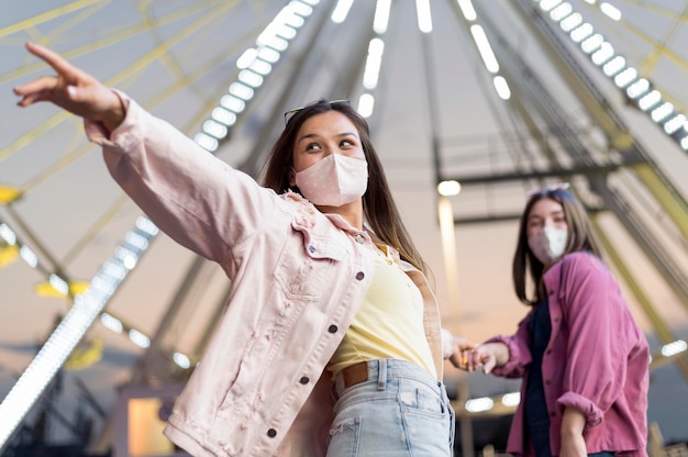 Gratis foto vriendinnen in het pretpark met medische maskers