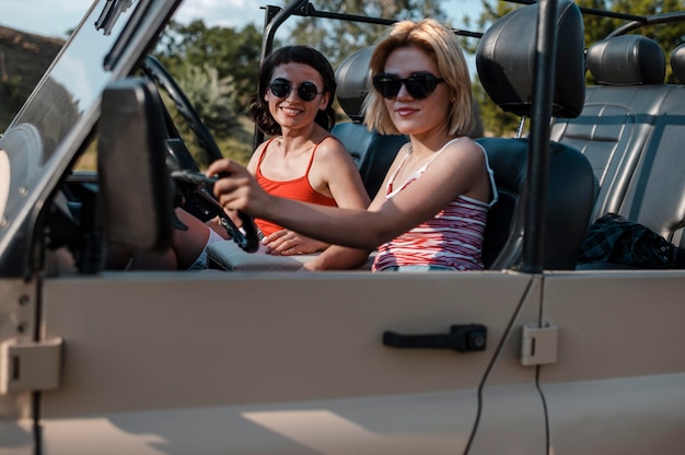 Gratis foto vriendinnen met zonnebril reizen met de auto