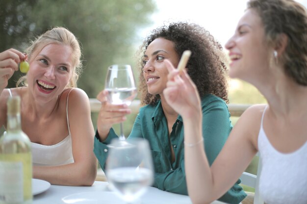 Vriendinnen naast elkaar wijn drinken en lachen