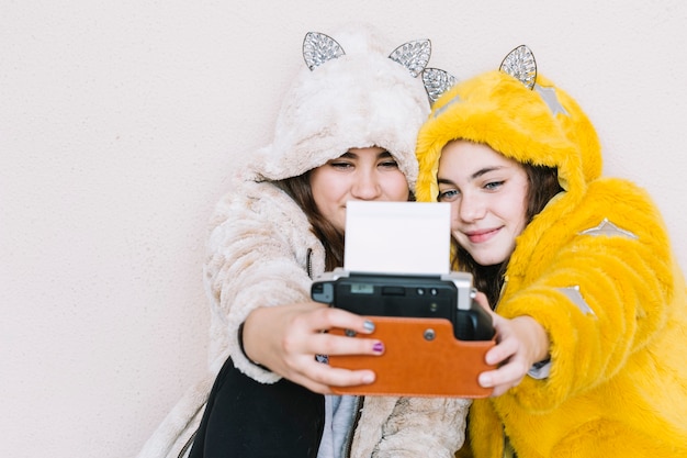 Vriendschapsconcept met twee meisjes die selfie met onmiddellijke camera nemen