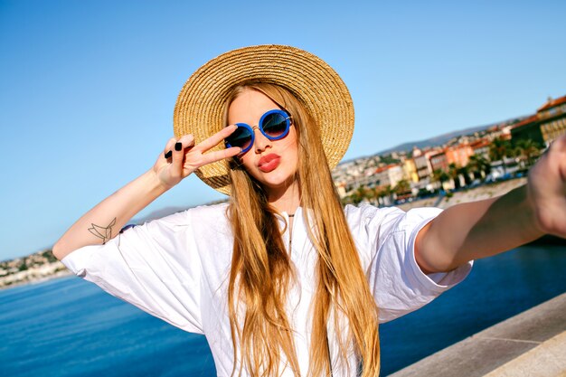 Vrij elegante blonde mooie vrouw selfie vooraan maken op mooi strand