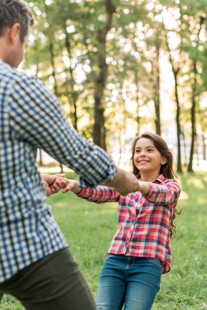 Vrij het glimlachen meisje het spelen met haar vader in park