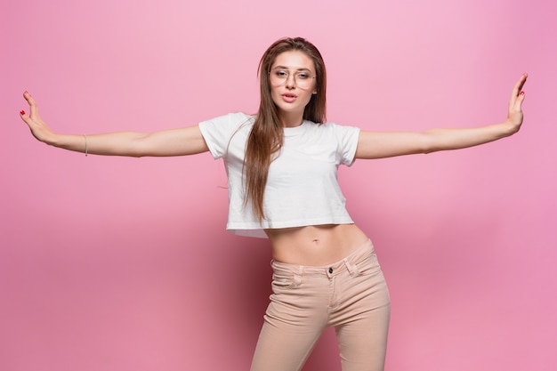 Vrij het jonge sexy manier sensuele vrouw stellen op roze muur gekleed in jeans van de hipsterstijl