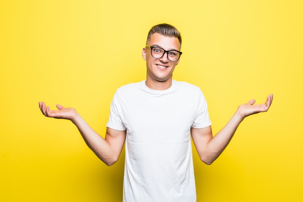 Vrij jonge jongen toont niets teken gekleed in een wit t-shirt en een transparante bril