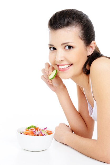 Vrij jonge vrouw die gezonde die salade eet - op wit wordt geïsoleerd