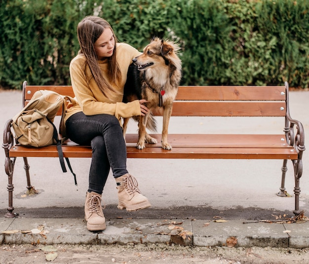 Vrij jonge vrouw die haar hond aait