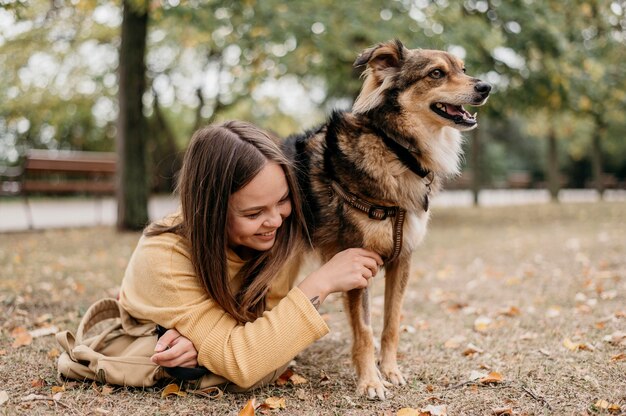 Vrij jonge vrouw die haar hond aait