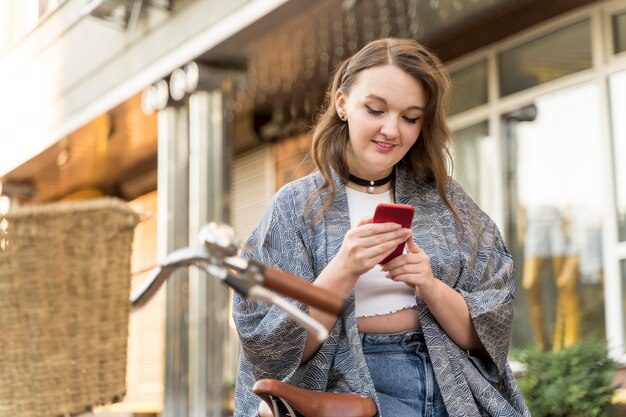 Vrij jonge vrouw die mobiele telefoon doorbladert