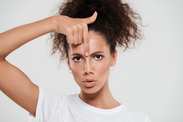 Gratis foto vrij jonge vrouw met krullend haar met wijsvinger